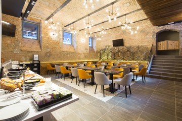 Interior of a modern hotel restaurant with brick wall
