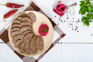 Home made dietary sausage from the liver on a white wooden table. Sausage cut into pieces on a...