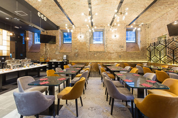 Interior of a modern hotel restaurant with brick wall