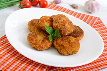 Cutlets. Juicy meat cutlets on a white plate on a wooden background.