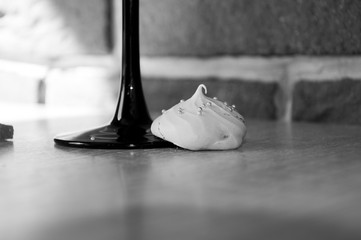 cocktail in the bar with meringue cookie at glass leg, black and white, copy space.
