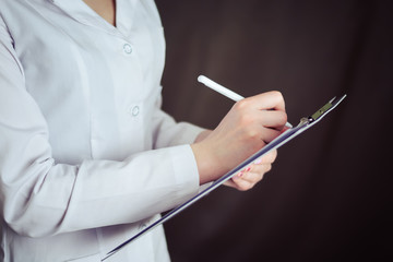 Female doctor hold clipboard pad and fill medical history list with pen