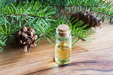 A bottle of essential oil with Douglas fir branches