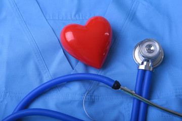 Doctor coat with medical stethoscope and red heart on the desk