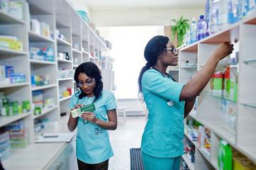 Two african american pharmacist working in drugstore at hospital pharmacy. African healthcare.