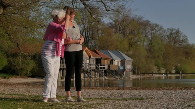 Seniorin mit junger Frau am See im Fr&uuml;hling