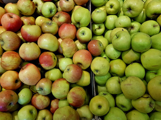 Fresh green apples lie in the shop window
