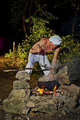 the cook is preparing food on the fire