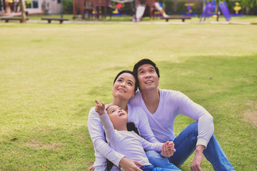 Happy male and female playing with children outside