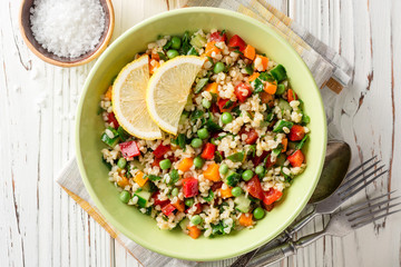 Fresh salad with bulgur and vegetables on white wooden table