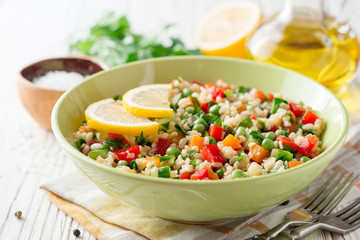 Fresh salad with bulgur and vegetables on white wooden table