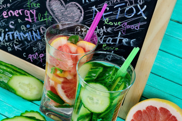 glass water with cucumber and grapefruit on table