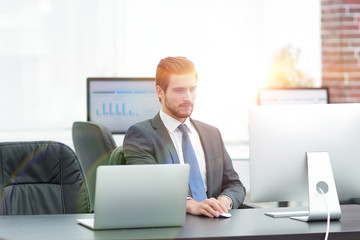 Young businessman using a computer on his desktop.