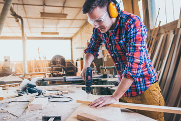 Carpenter At Work Using  Hand Drill