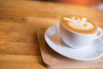 A Cup of hot latte art coffee on wooden table