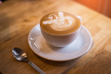 A Cup of hot latte art coffee on wooden table