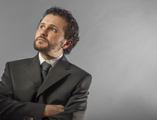 Portrait of confidence and success. Portrait of handsome mature man in shirt and tie keeping arms crossed and looking at camera while standing against grey background