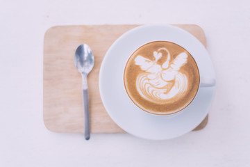 A Cup of hot latte art coffee on wooden table