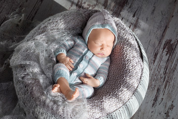 Beautiful little newborn boy 20 days  sleeps in a basket. Portrait of pretty newborn boy