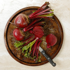 Fresh beetroots on metal tray on marble table with knife with square format