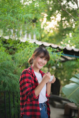 asian beautiful woman drinking hot coffee or tea in the green garden