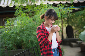 Fototapeta premium asian beautiful woman drinking hot coffee or tea in the green garden