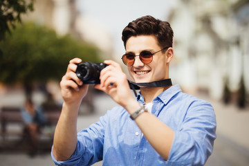 Tourist Man With Camera Taking Photos On Street. Portrait Of Handsome Smiling Male Holding Camera, Making Photo Of Interesting Places While Walking In Old City.