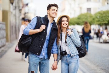Fototapeta premium Young freelancing photographers enjoying traveling and backpacking. Young couple with backpack travel new destination