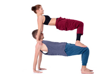 Obraz premium Young athletic couple practicing acroyoga. Balancing in pair.
