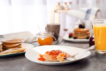 Delicious pancakes with jam served for breakfast on table