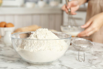 Bowl with flour and woman on background