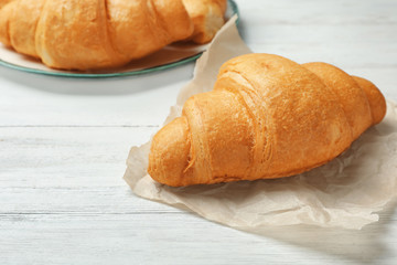 Tasty croissant on wooden table