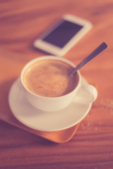 Cup of art latte or cappuccino coffee with retro filter effect