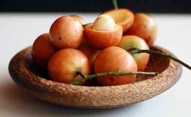 Menteng fruit or Baccaurea racemosa on wood plate.