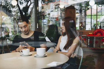 Couple using a phone at a cafe
