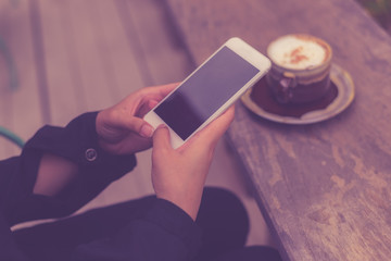 Touching screen of her smart phone at coffee shop