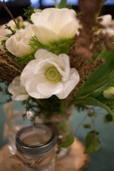 Yellow and White Spring Flower Centerpiece in a Glass Canning Jar on a Wooden Slab
