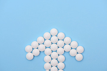 blue medicine background whith arrow of white pills