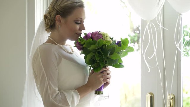 Bride smelling flowers in wedding bouquet.