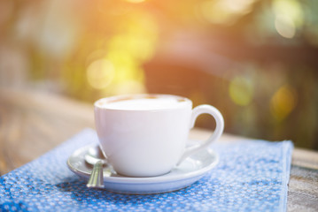 Coffee espresso on wood table nature background in garden,warm tone