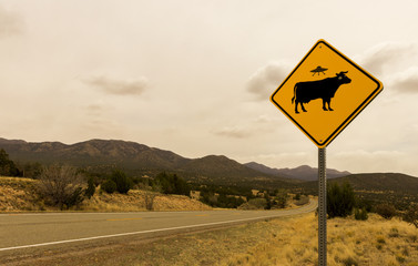 Obraz premium Cow Alien Abduction Road Sign wzdłuż Szlaku Turqoise, Route 66 Scenic Byway, na wiosnę między Santa Fe i Albuquerque, Nowy Meksyk.