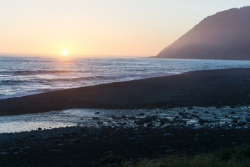 A colorful beach sunset over the black sands of the Lost Coast backpacking trail in California