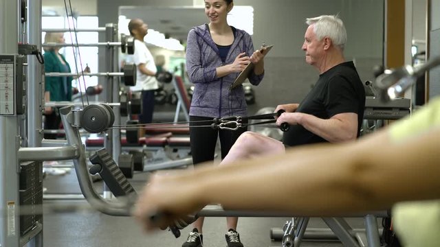Senior man working out with a rowing machine
