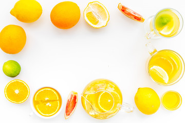 Fruit tea. Teacup and teapot among citrus on white background top view copy space