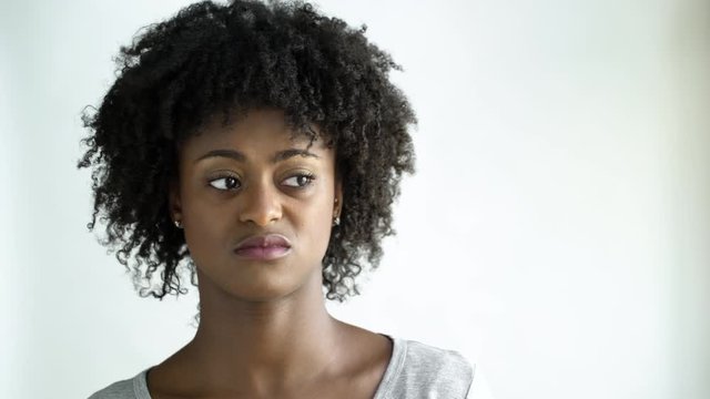 Displeased young woman with afro, studio shot.