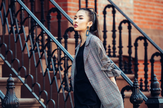 Beautiful asian girl walking on urban city neighborhood street wearing fashionable clothes