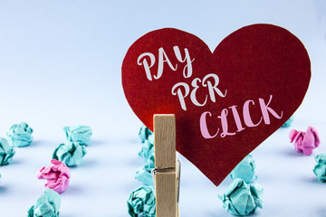 Handwriting text Pay Per Click. Concept meaning Get money from visitors Ads Advertising SEO Marketing written on Red Paper Heart holding by Clip on plain background Paper Balls next to it.