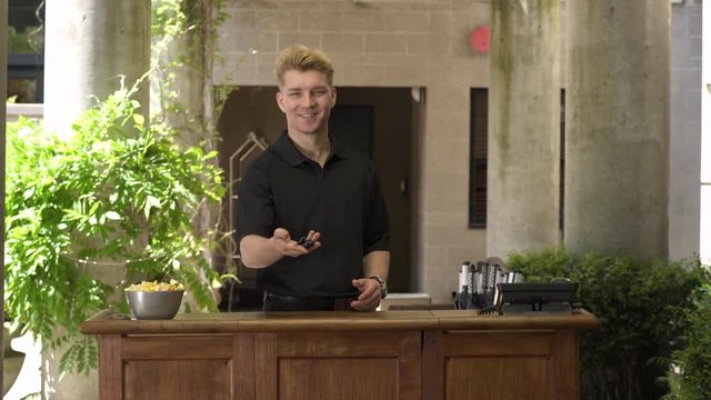 Doorman offering keys while looking at camera