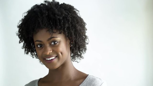 Young woman with afro smiling , studio shot.