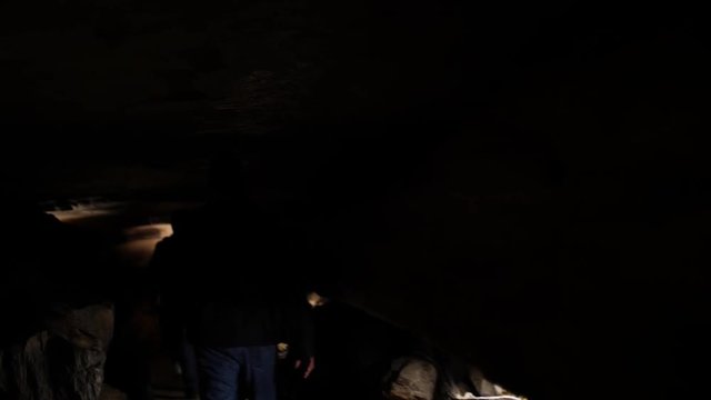 People walking inside dark cave